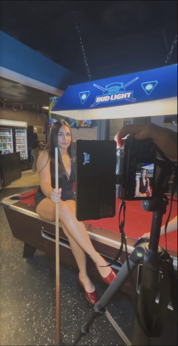 Sesión de contenido con cámara profesional en un bar con mesas de pool
